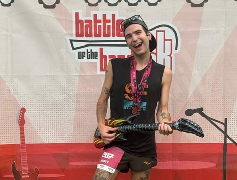 Man holding inflatable guitar after running